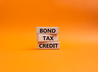Bond Tax Credit symbol. Concept word Bond Tax Credit on wooden blocks. Beautiful orange background. Business and Bond Tax Credit concept. Copy space