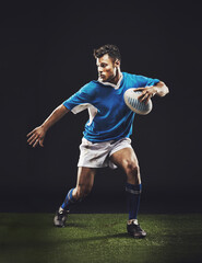 Rugby, black background and man athlete running in dark studio while training, wellness and fitness sports. Exercise, workout and professional career of sport male person or player on grass © Duncan M/peopleimages.com