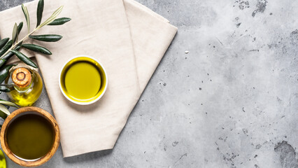 Food background with linen napkin, olive tree branch, olive oil on concrete background
