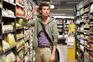 Confused, portrait and a man doing grocery shopping at a supermarket with doubt and thinking....