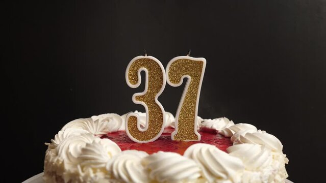 A candle in the form of the number 37, inserted into the holiday cake, is blown out. Celebrating a birthday or a landmark event. The climax of the celebration.