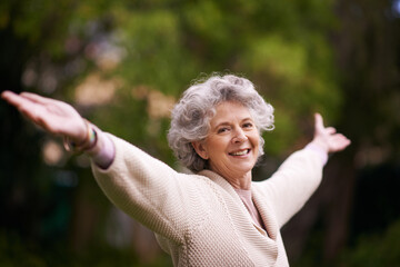 Portrait, happiness and senior woman with open arms in backyard garden or lady with a happy smile on face, celebrate life. Healthy, smiling pensioner stretching with freedom and success in retirement