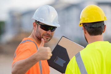 Hispanic man construction worker with thumb up in helmet at building. Construction building. Construction site manager. Worker in helmet on the new building.