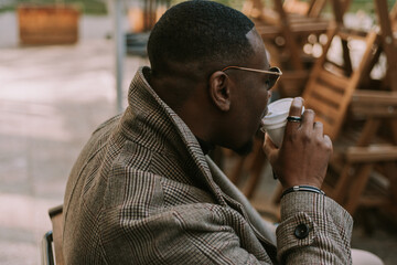 A close up shot of black handsome businessman taking a sip of his first morning coffee