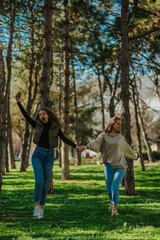 Two happy girls jumping and singing while walking in the park. They are hanging out on a sunny day