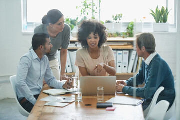 Discussion, laptop and business people in the office planning a project together in boardroom. Meeting, teamwork and professional web designers working in collaboration with a computer in workplace.