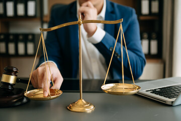 Male lawyer in the office with brass scale on wooden table. justice and law concept