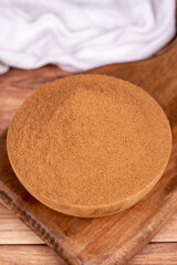 Cinnamon powder on wooden background. Powdered dried cinnamon in wooden bowl