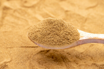 Powdered cinnamon on wooden spoon. Pile of cinnamon powder. close up