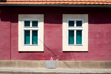 Window in the pink wall of the old house.
