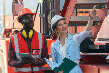 group of two african american  engineer man and inspector Caucasian woman talking and checking list inventory by tablet computer loading Containers box at warehouse logistic in Cargo. diversity worker