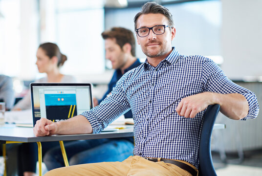 Smile, desk and portrait of a businessman at work for web design, creativity or expert at an agency. Happy, creative and a mature designer with a laptop for a website, email or graphic professional