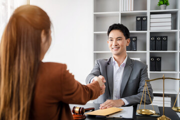 Lawyer shaking hands with client after discussing final contract agreement