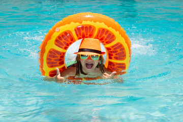 Summer fun kids face. Kid swim with floating ring in swimming pool. Kids summer vacation. Happy child boy with inflatable ring in poolside.