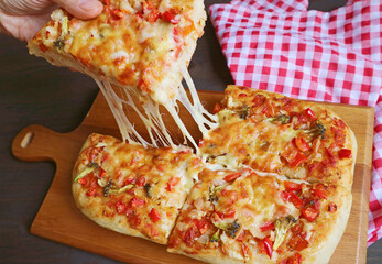 Hand Picking a Slice of Freshly Baked Pizza Alla Pala with Mouthwatering Stretching Cheese