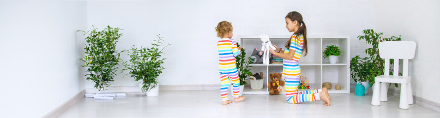 The sister child is playing in the room. Selective focus.