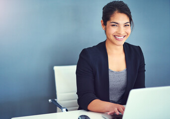 Confidence, portrait and businesswoman working in the office on laptop by wall with mockup space....