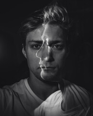 Chaotic thoughts displayed with a double exposure of a man in a dark room.