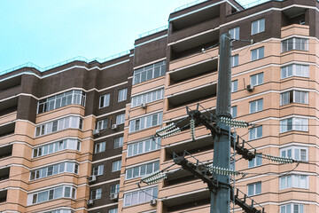 Moscow, Russia - 23 May 2023: Brick multi-storey brown house and power line in the foreground.