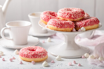 Sweet and homemade pink donuts and coffee as perfect snack..