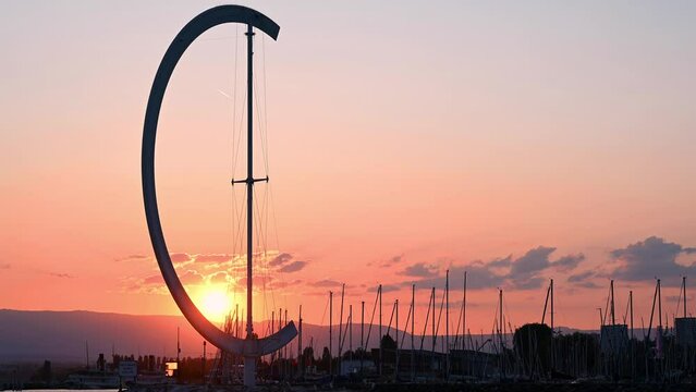 Sunset over lake. Landscape of lake Geneva, mountain and Ouchy waterfront statue. Port of Ouchy, Lausanne, Vaud Canton, Switzerland. Real time.