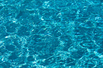 Ripple Water in swimming pool with sun reflection. Wavy water background.