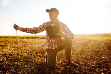 Farmer touching soil on the field before growth a seed of vegetable or plant seedling. Agriculture,...