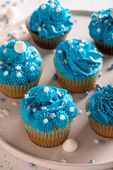 Delicious and homemade cupcakes with blue whipped cream.