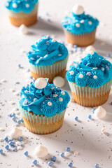 Beautiful and unique cupcakes with blue cream and sprinkles.