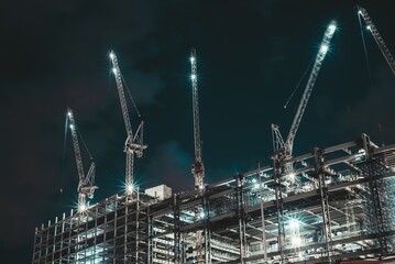 Moscow, Russia - 8 June 2023: Night photo of a skyscraper under construction in the center of Moscow, on the roof of which there are large cranes, Moscow City.