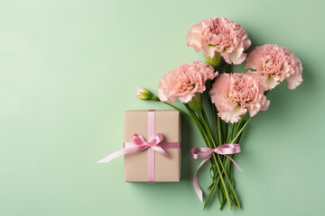 Top view of pink present boxes with ribbon, carnation flowers on a soft pastel green background with copy space, Generative AI