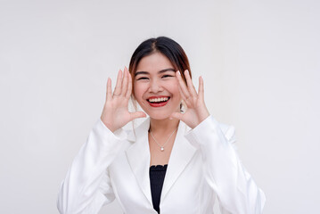 A beaming and joyful young lady yelling with cupped hands while looking at the camera. Isolated on a white background.