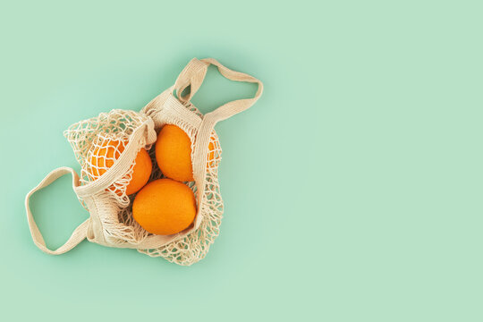 string bag with orange fruits, sustainable string bag for responsible consumers, copy space