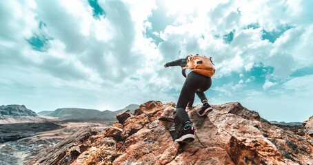 Hiker woman with backpack standing on the top of the mountain - Happy climber enjoying freedom - Inspirational photo with successful person winning challenge
