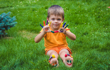 Children's hands in the colors of summer, a smile on the boy's palm.