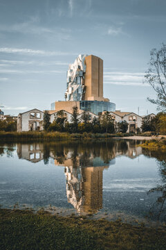 Arles, France, June 06 2023. Luma Tower, Frank Gehry, with reflections on the water of the lake of the park. This tower is part of the great project of Maja Hoffmann in Camargue, Provence.
