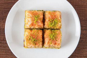 Turkish baklava with pistachio in plate.A plate baklava on wooden background,top view
