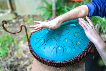 Close-up of hands playing Tongue drum, Vadjraghanta or hand pan