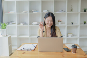 Successful Businesswoman Embracing Technology in the Modern Workplace. Woman smiling and using laptop for video conference.
