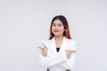 A smiling and positive young woman with arms crossed and pointing towards opposite directions. Isolated on a white background.
