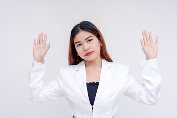 A composed and poker faced young woman with arms raised in surrender. Isolated on a white...