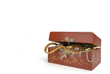 A Handmade Wooden Jewellery Case Painted in Folk Art Style Brimming Over with Jewellery and other Valuables Isolated on White Background.