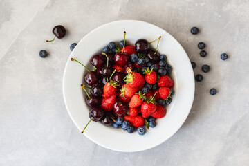 Seasonal summer vitamin plate with different fruits on stone background top view, healthy eating