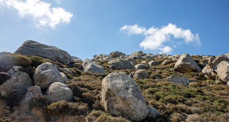 Fototapeta na wymiar Huge granite rock that surrounds Volax village in Tinos island Cyclades Greece. Summer day blue sky