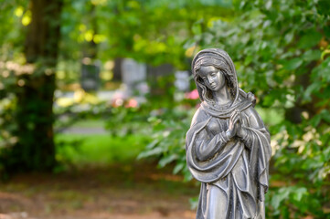 Fototapeta na wymiar Betende Madonnenfigur am Friedhof