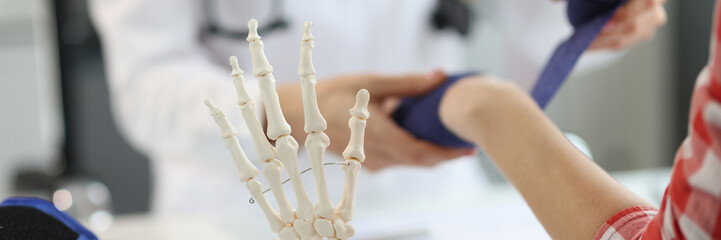 Hands of traumatologist doctor bandages female hand. Injuries and sprains of hands concept