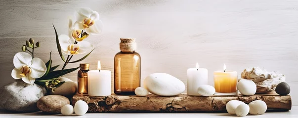 Fototapeten Beauty treatment items for spa procedures on white wooden table and marble wall. massage stones, essential oils and sea salt. candle, rolled up white towel, plants, copy space © Savinus