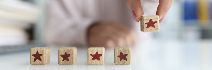 Five stars reviews review and rating concept. Manual installation of blocks in the form of five stars closeup