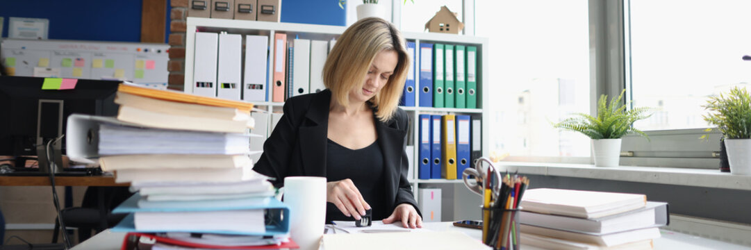 Businesswoman or secretary in office and stamping document. Notarial activity and approved contract