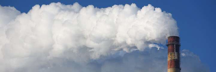 Toxic clouds of smoke come out of factory chimney. CHP and smoking chimneys concept